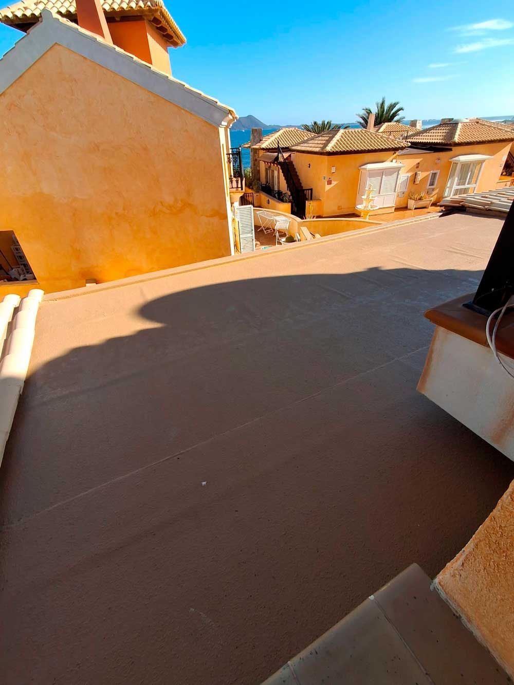 Una azotea con vista a una ciudad y al océano.