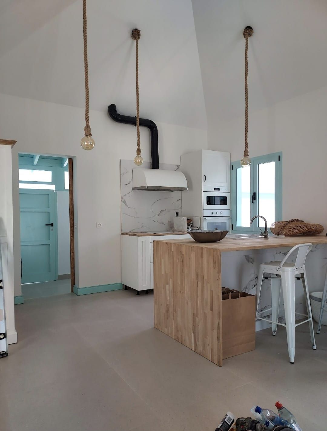 Una cocina con gabinetes blancos y una isla de madera.
