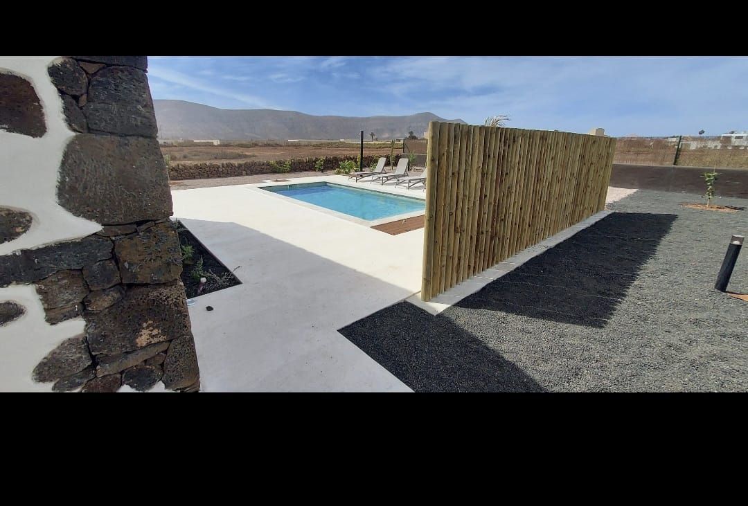 Una gran piscina está rodeada por una valla de madera.