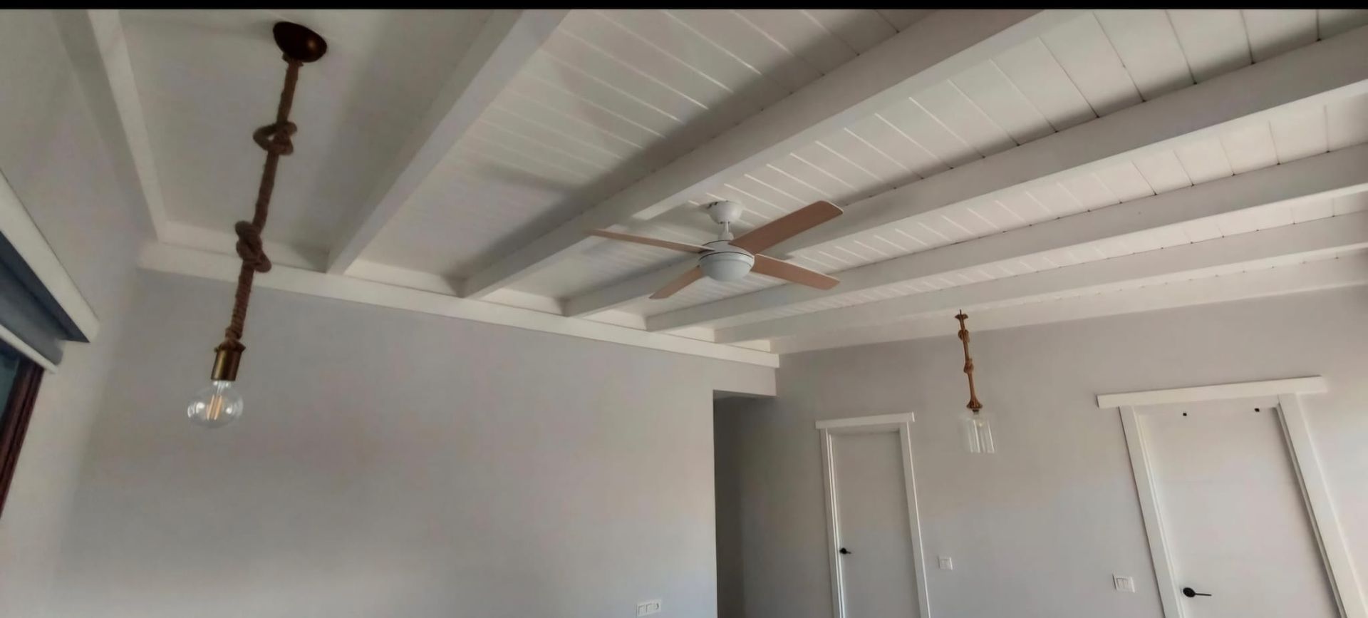 Un ventilador de techo cuelga del techo de una habitación.