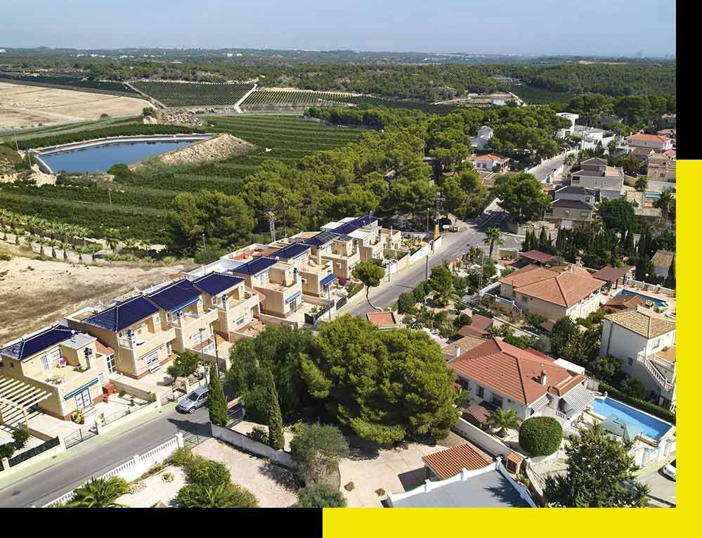 Un hombre con traje y corbata está de pie junto a un coche blanco.