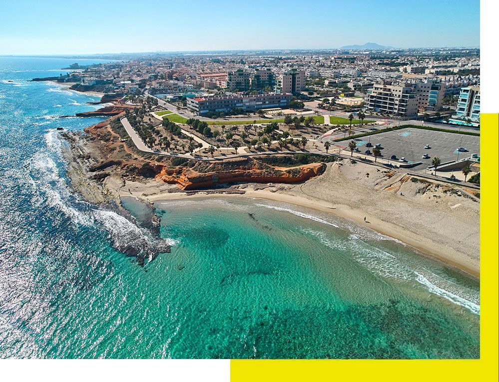 Una camioneta blanca está estacionada frente a un avión que vuela en el cielo.