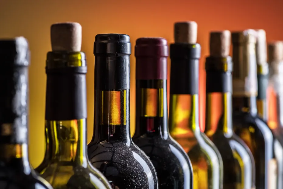 Una fila de botellas de vino están alineadas en una fila.