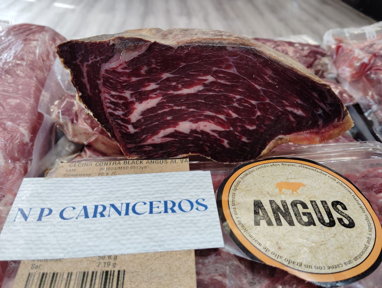 Un trozo de carne de Angus está junto a un paquete de carne.