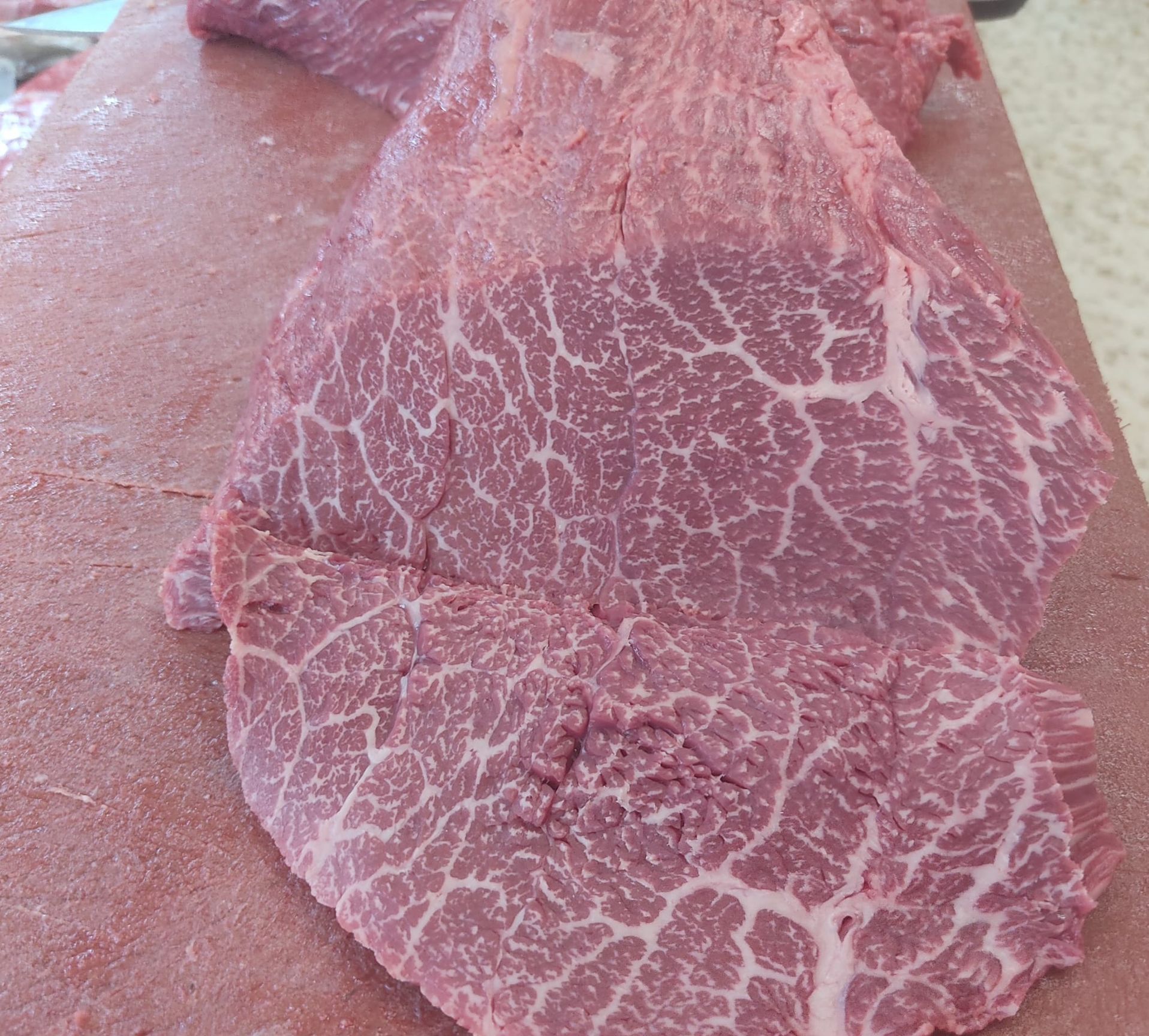 Un primer plano de un trozo de carne en una tabla de cortar.