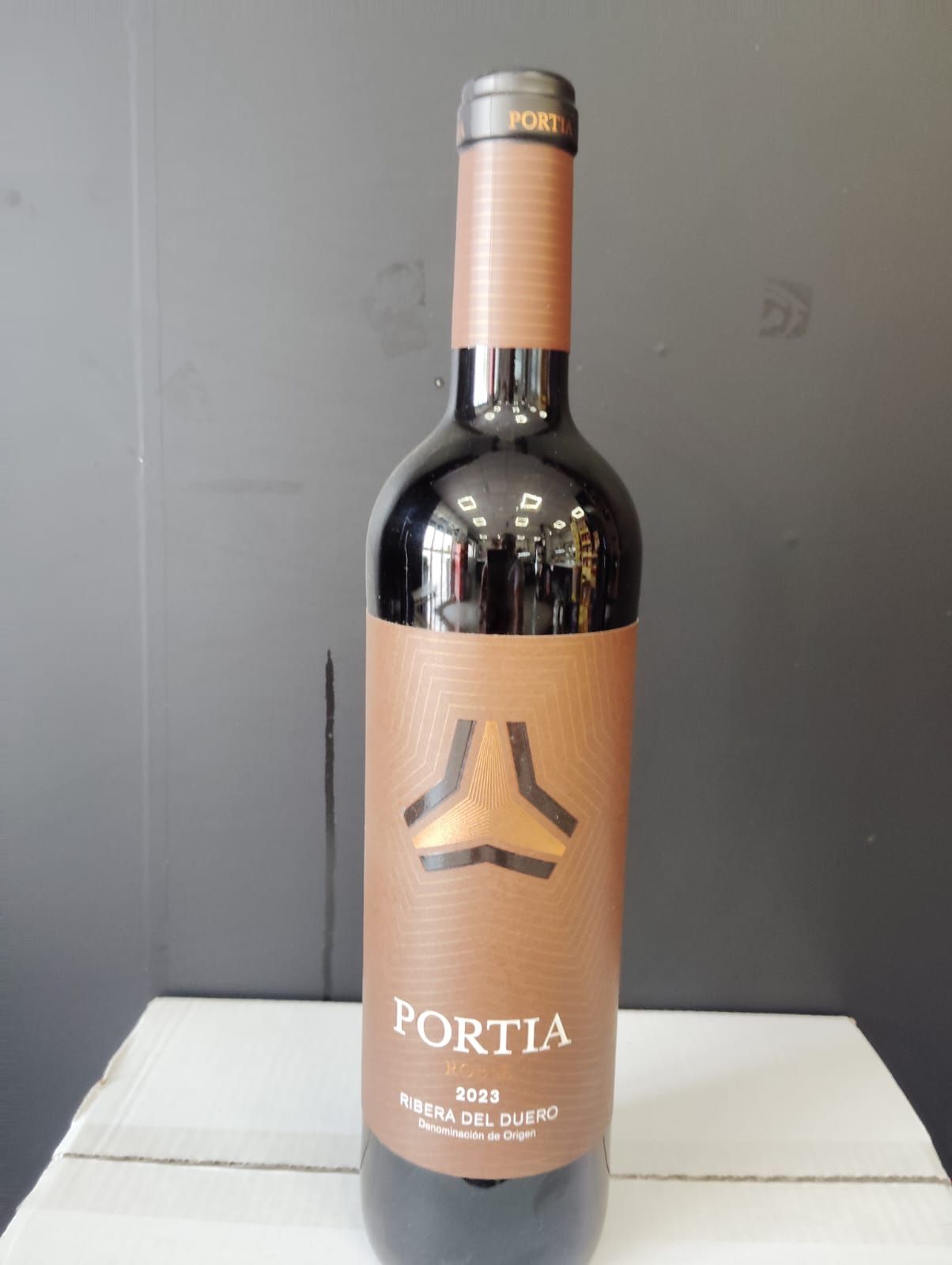 Una botella de vino oporto se encuentra sobre una caja
