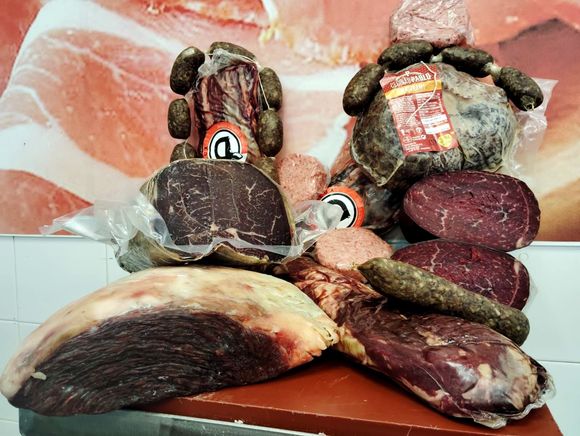 Un montón de carne y salchichas están sobre una mesa.
