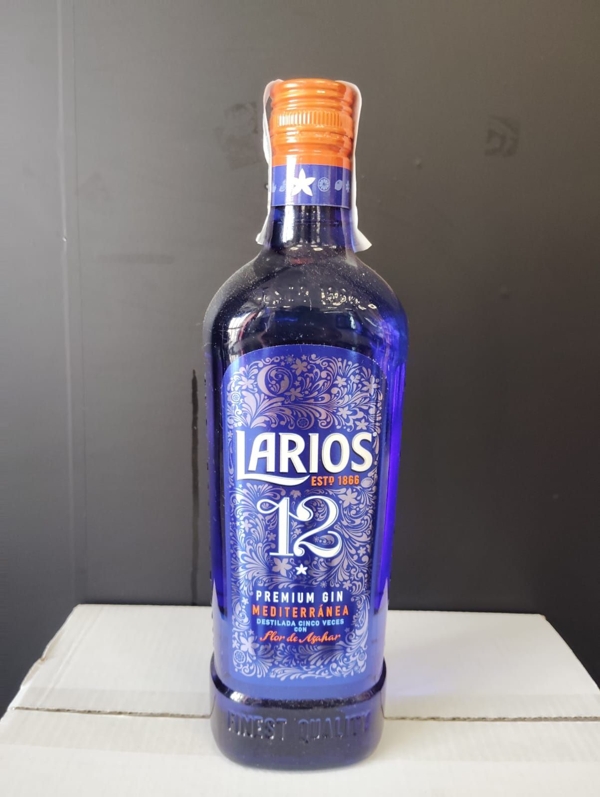 Una botella de ginebra Larios está sobre una mesa.