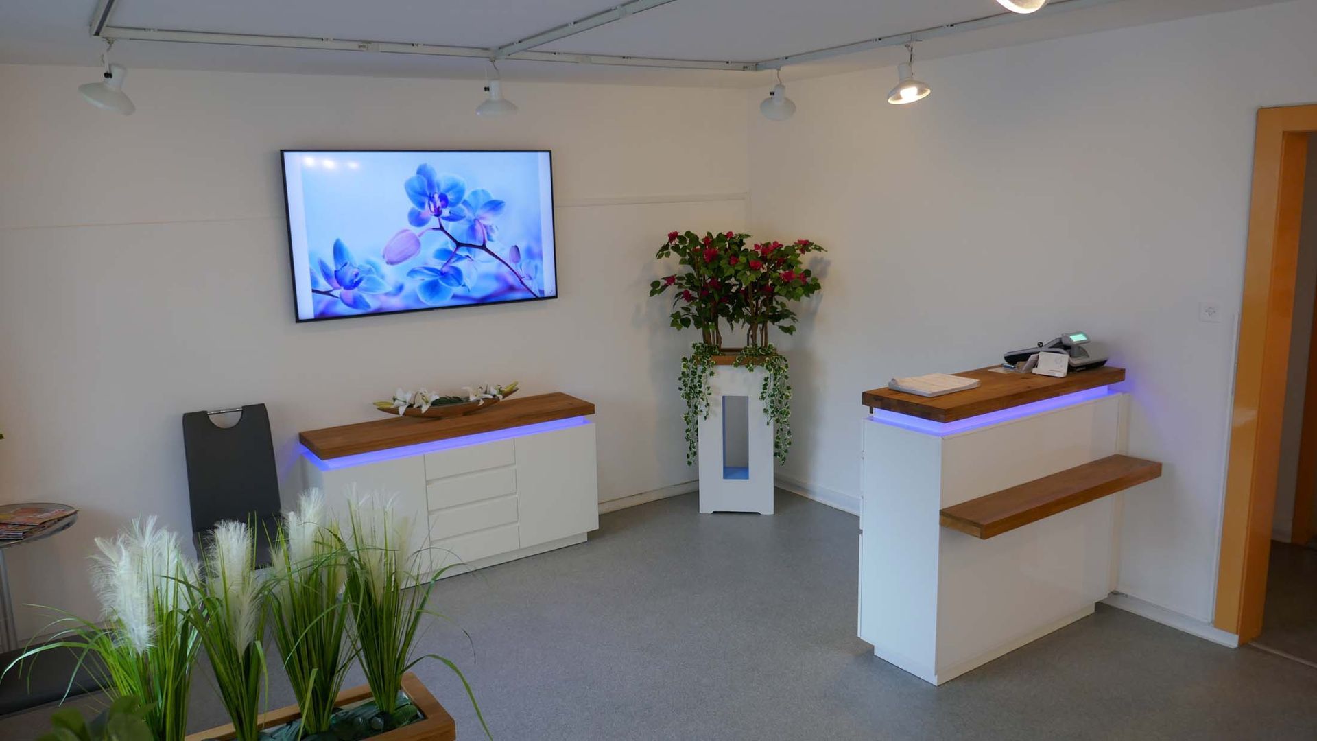 Ein Wohnzimmer mit einem Flachbildfernseher an der Wand.