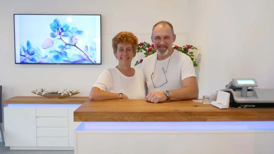 Ein Mann und eine Frau stehen an einem Tresen in einem Raum.