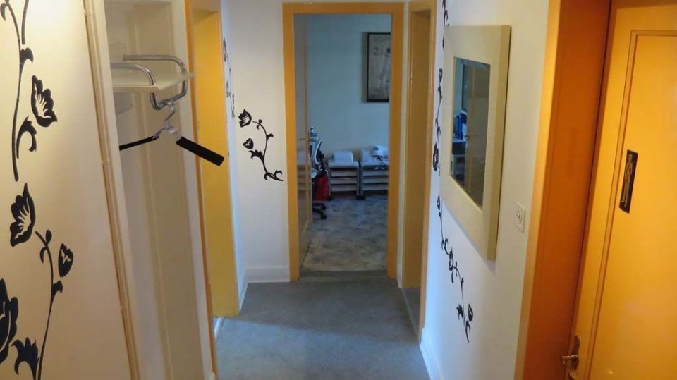 Ein Flur mit einem Spiegel an der Wand und einer Uhr an der Wand.