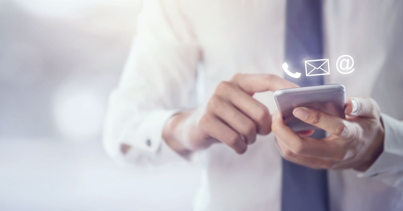 Les mains d'une personne qui tient le téléphone portable avec des pictogrammes de contact.