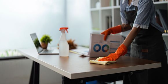 Une personne qui est en train de nettoyer un bureau.