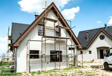 Maison avec façade blanche et un échafaudage.