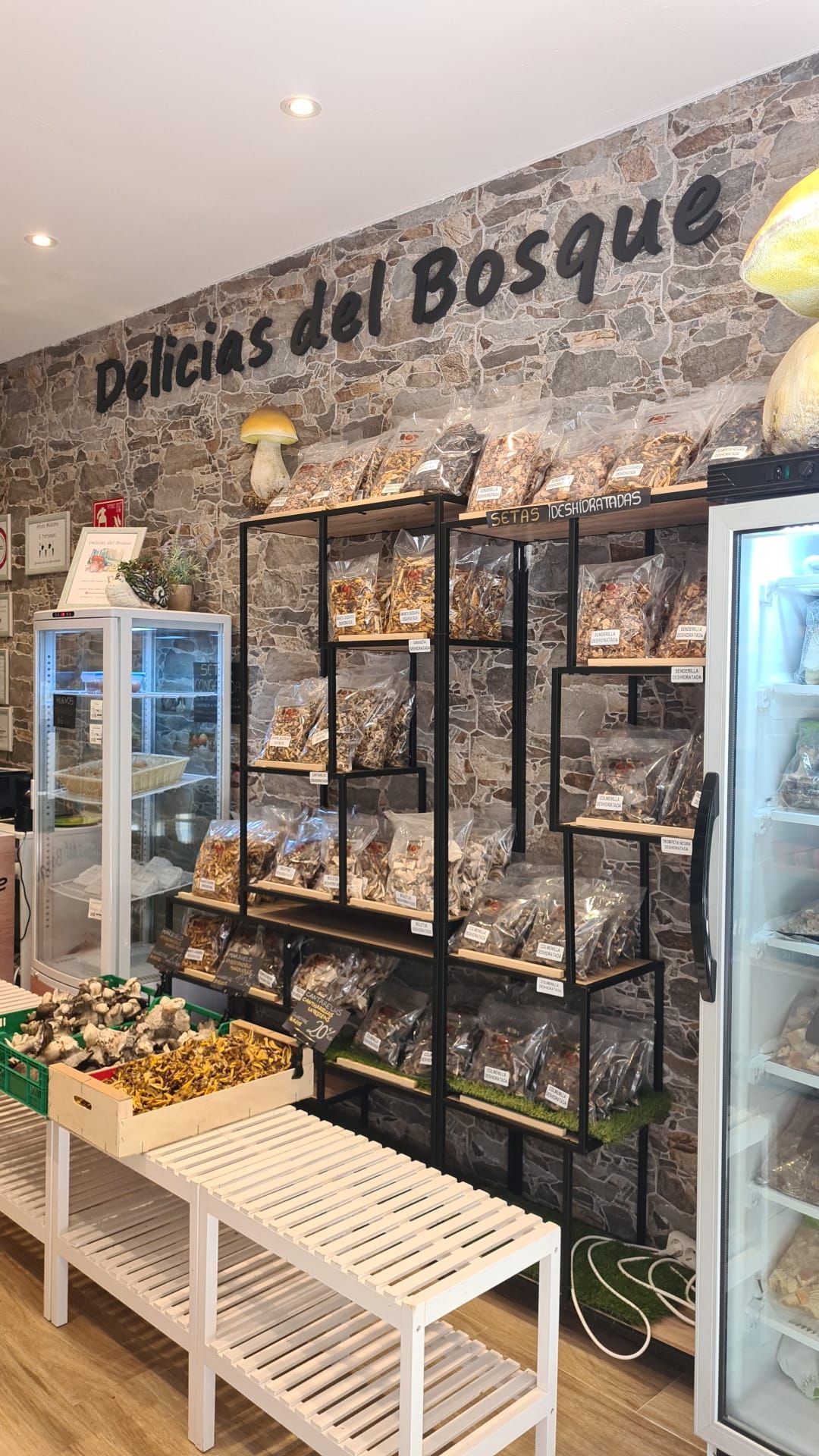 Una tienda llena de mucha comida y un cartel que dice delicias del bosque.