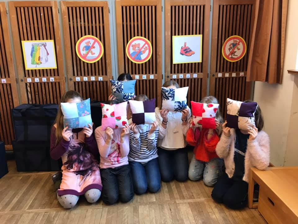 Kinder mit selbstgenähten Kissen vor dem Gesicht