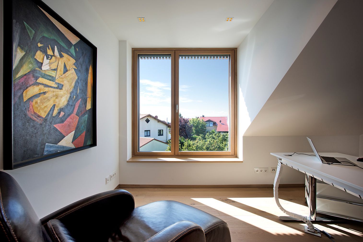 Ein Zimmer mit einem Stuhl, einem Schreibtisch und einem Gemälde an der Wand