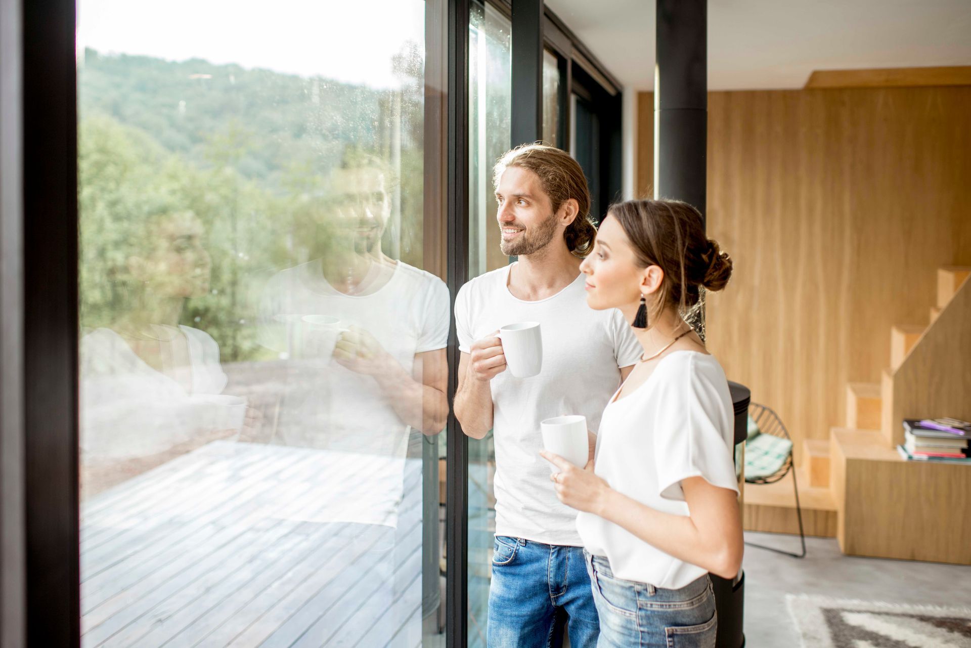 Ein Mann und eine Frau trinken Kaffee und schauen aus dem Fenster.