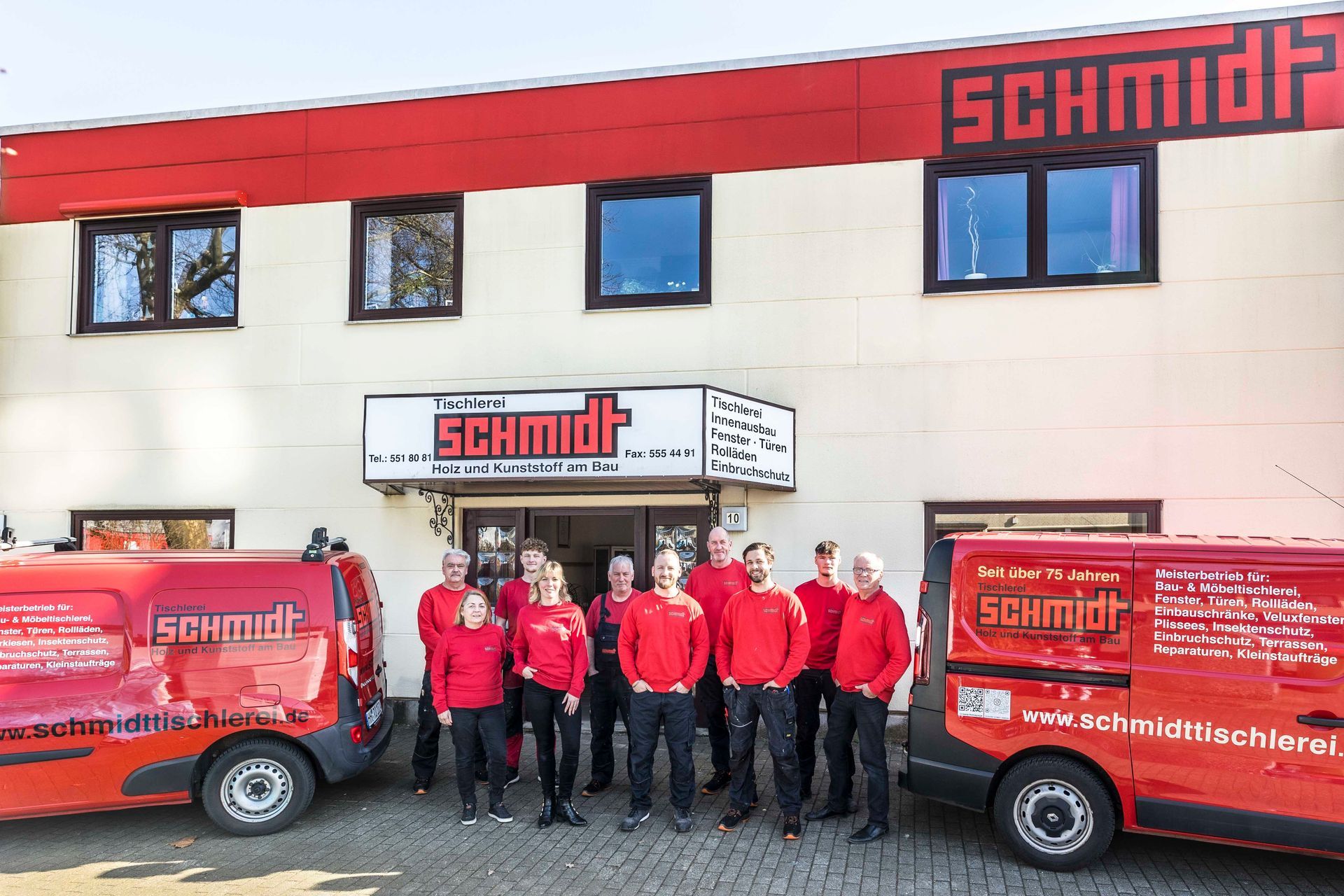 Eine Gruppe von Menschen steht vor einem Schmidt-Gebäude