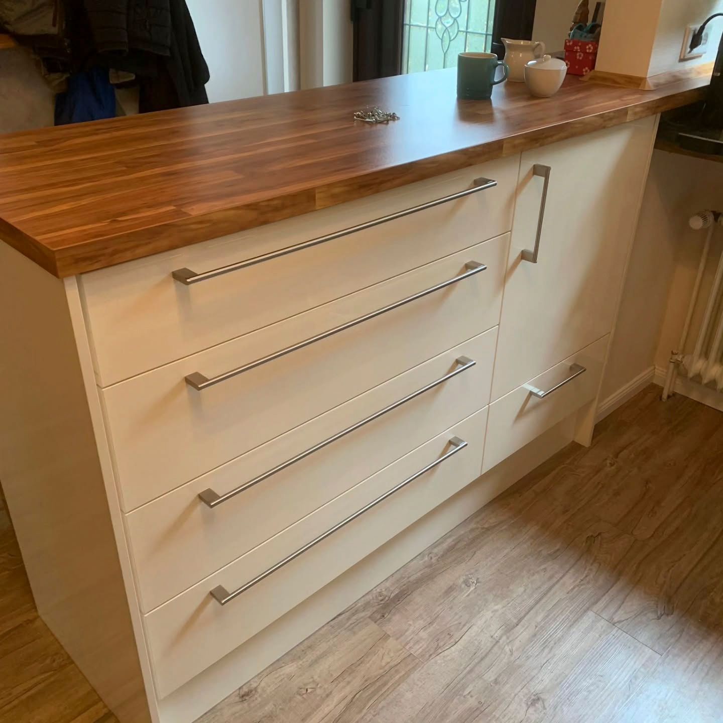 Eine Kommode mit weißen Schubladen und einer Holzplatte