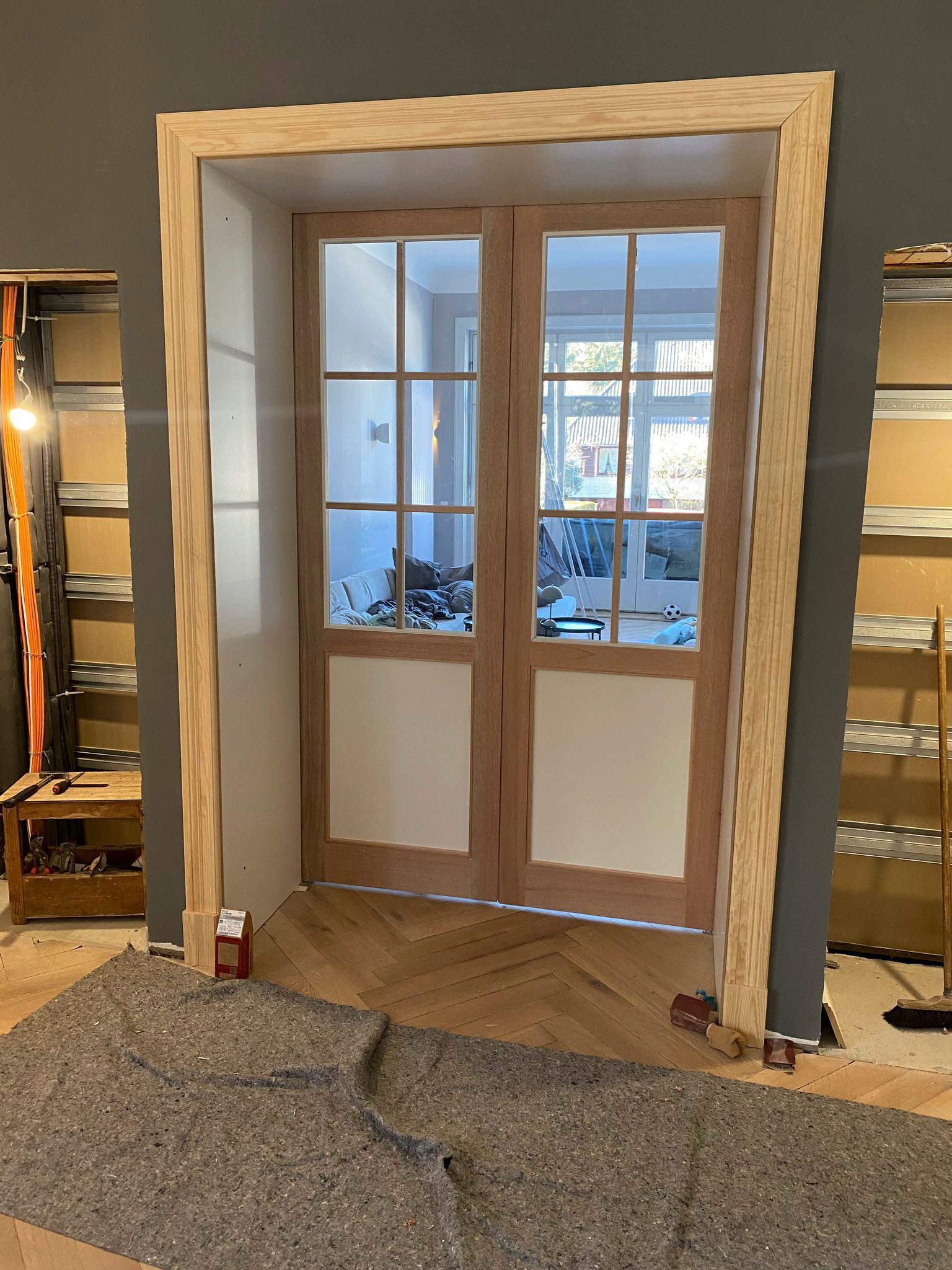 In einem Raum wird ein Paar Holztüren eingebaut.