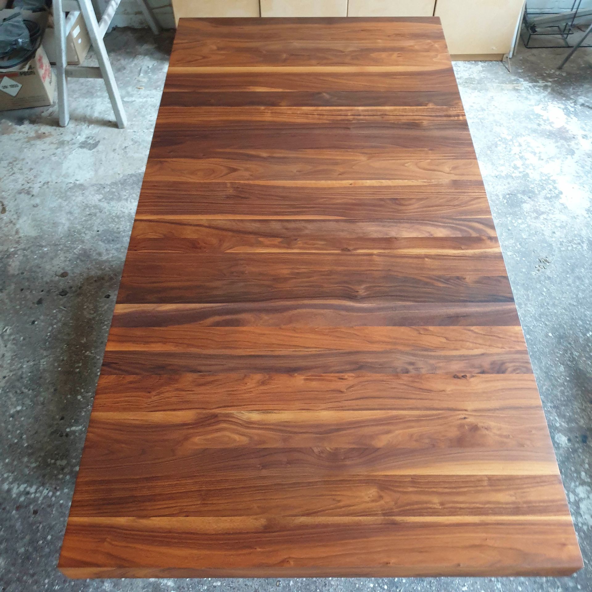 Ein Holztisch steht auf einem Betonboden