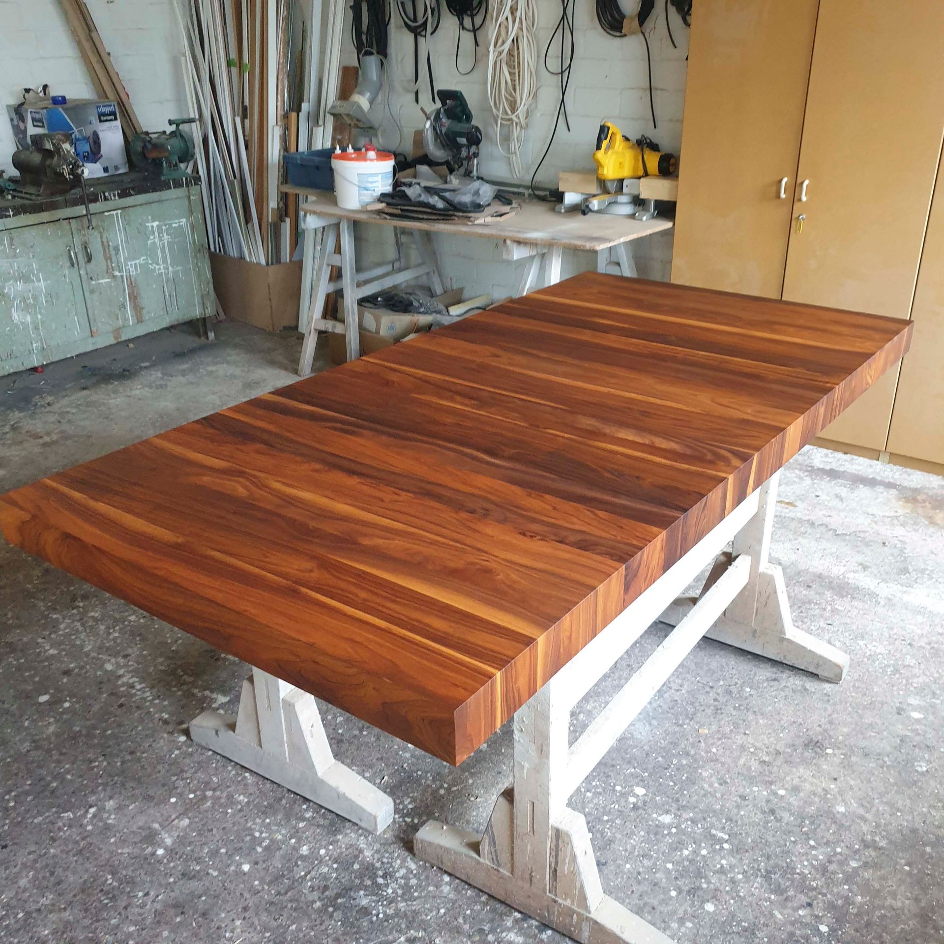 Ein Holztisch mit weißem Untergestell in einer Werkstatt