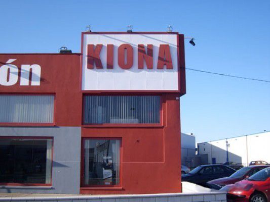 Un edificio rojo con un cartel blanco que dice Kiona.