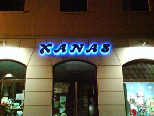 Un escaparate con un letrero de neón que dice Kanas.