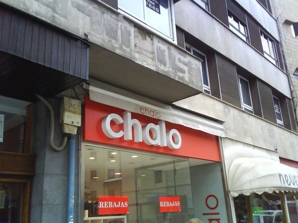 Un escaparate con un cartel rojo que dice chalo