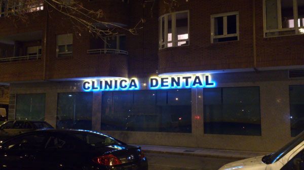Un cartel de clínica dental está iluminado por la noche.