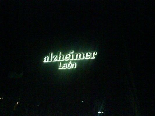 Un cartel que dice Alzheimer Leon está iluminado en la oscuridad.