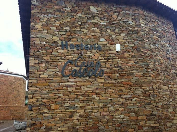 Un gran muro de piedra con un cartel en él.