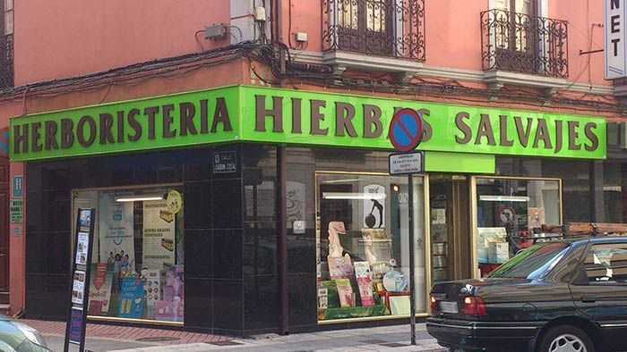 Un escaparate con un cartel verde que dice herboristeria hierbas salvajes