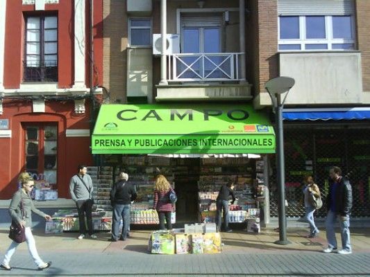 Un escaparate con un toldo verde que dice campo