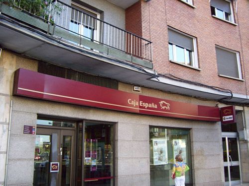 Un edificio con un toldo rojo que dice caja espana