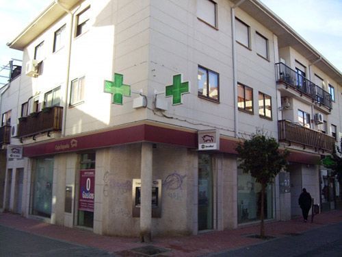 Un edificio con una cruz verde en el costado.