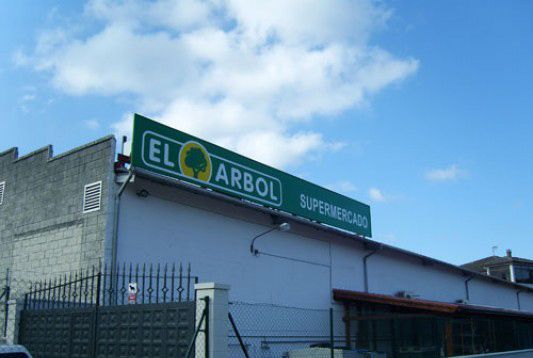 Un edificio con un cartel verde que dice el arbol.