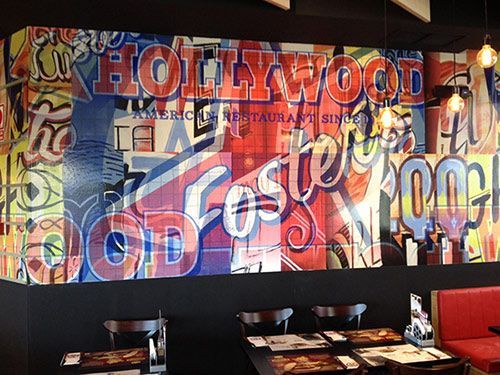 Un restaurante con un mural en la pared que dice Hollywood.