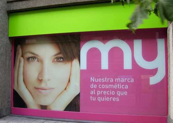 A woman 's face is on a sign that says my nuestra marca de cosmetica al precio que tu quieres