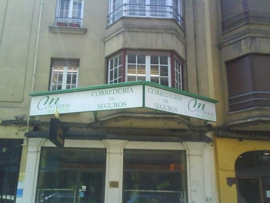 Un edificio con un toldo verde que dice om