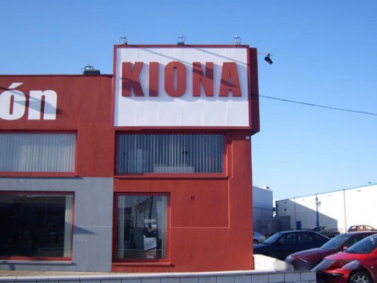Un edificio rojo con un cartel blanco que dice Kiona.