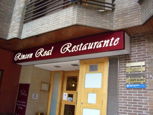 Un edificio con un cartel rojo que dice Rincon Real Restaurante.