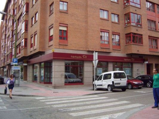 Una camioneta blanca está estacionada frente a un edificio de ladrillos.