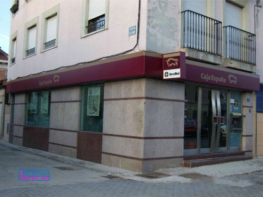 Un edificio con un cartel rojo que dice Cola Española.