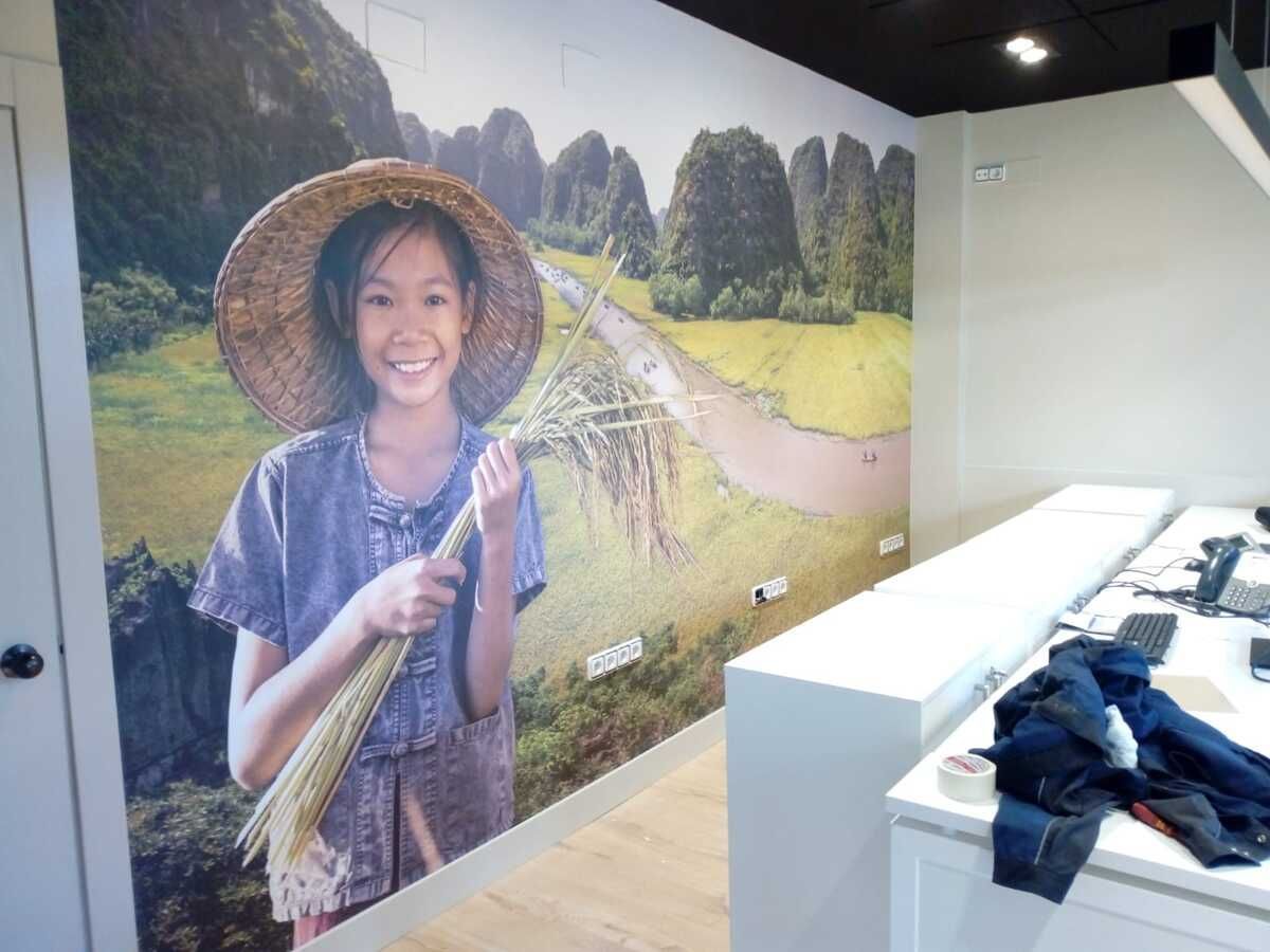 Una niña con un sombrero de paja sostiene una escoba en una habitación.