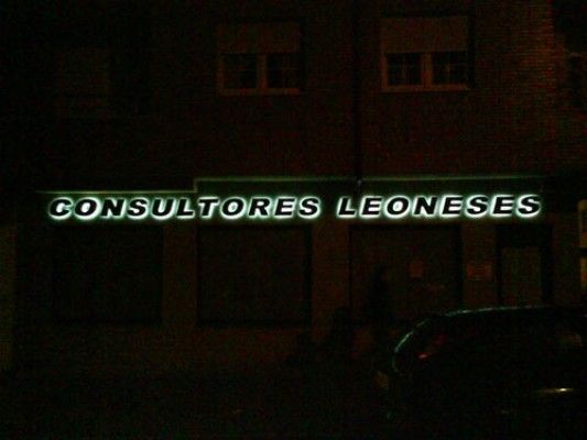 Un cartel de Consultores Leoneses se ilumina por la noche