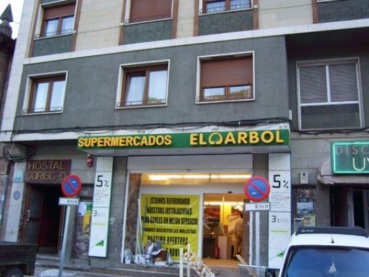Un edificio con un cartel que dice supermercados eloarbol