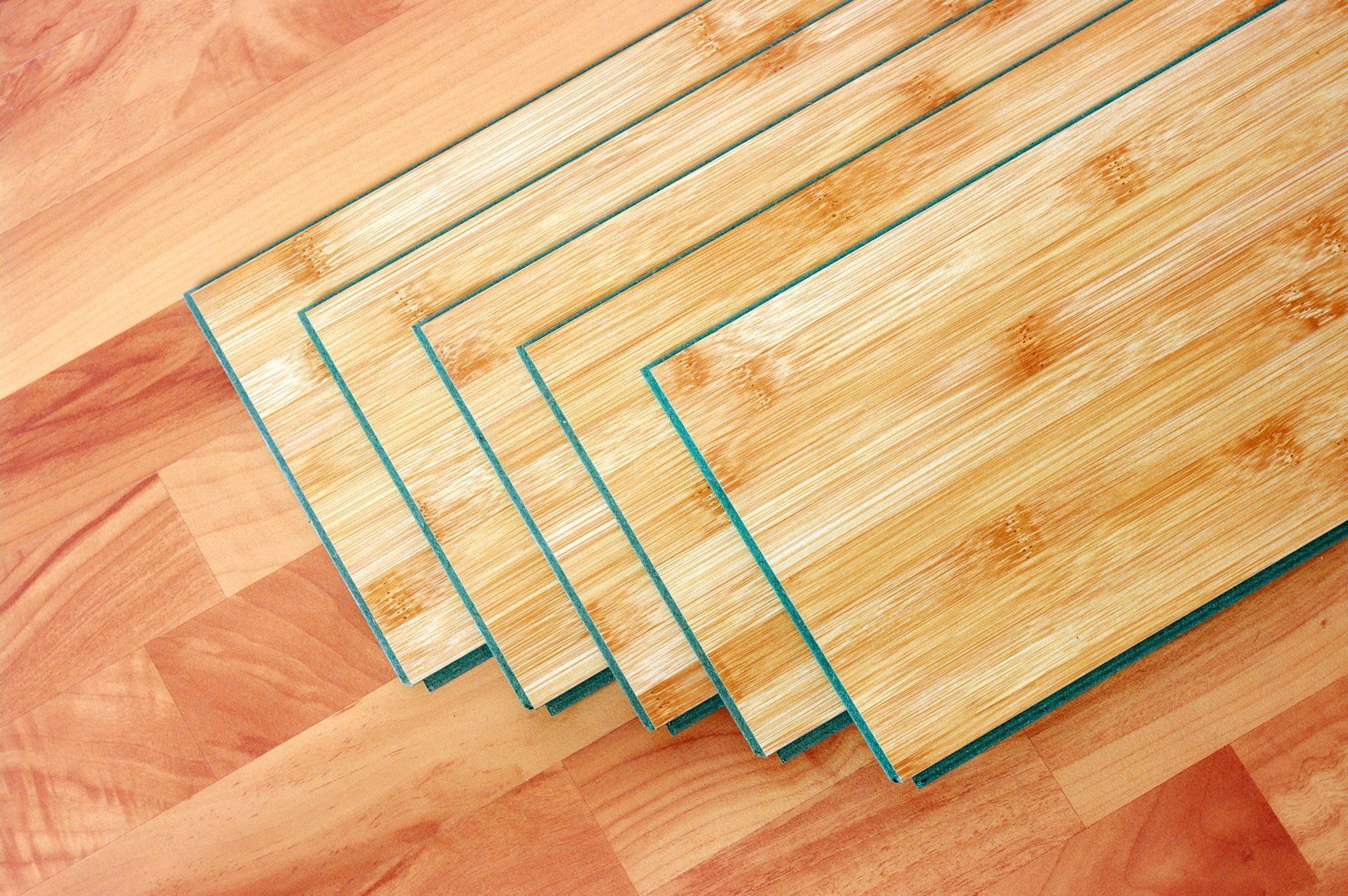 Lames de parquet en bambou empilées avec des bords verts sur une surface en bois