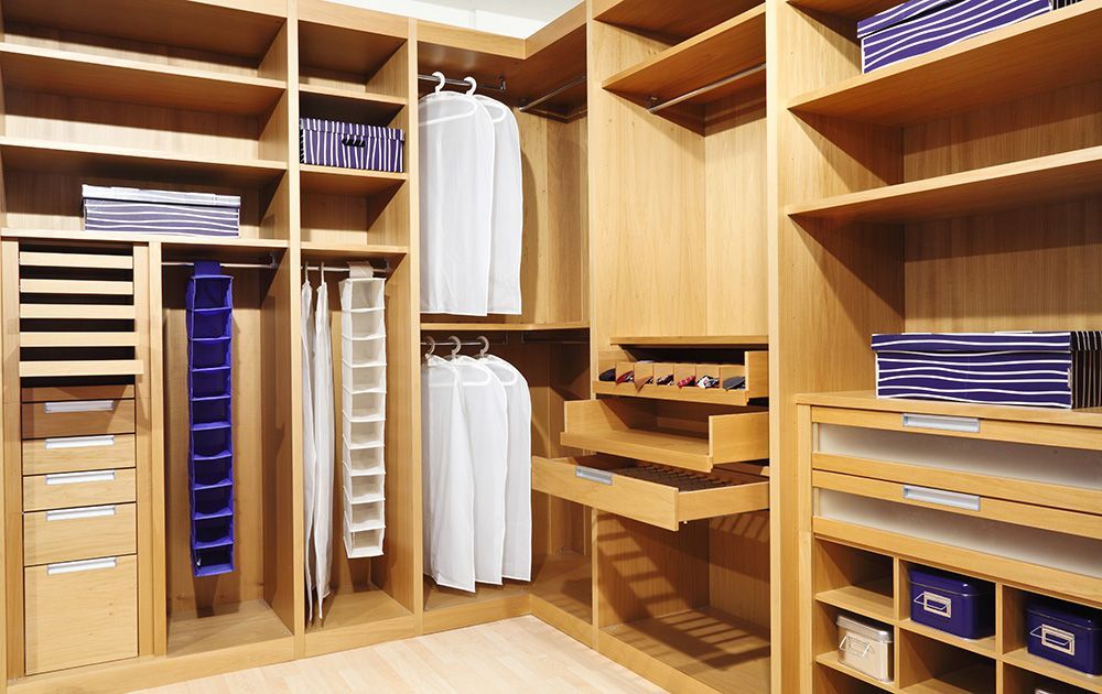 Placard intégré en bois avec étagères, vêtements suspendus, linge plié et tiroirs